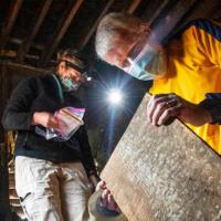 people looking at a piece of wood