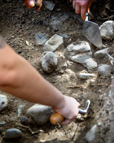 Students excavating with a trowel. 